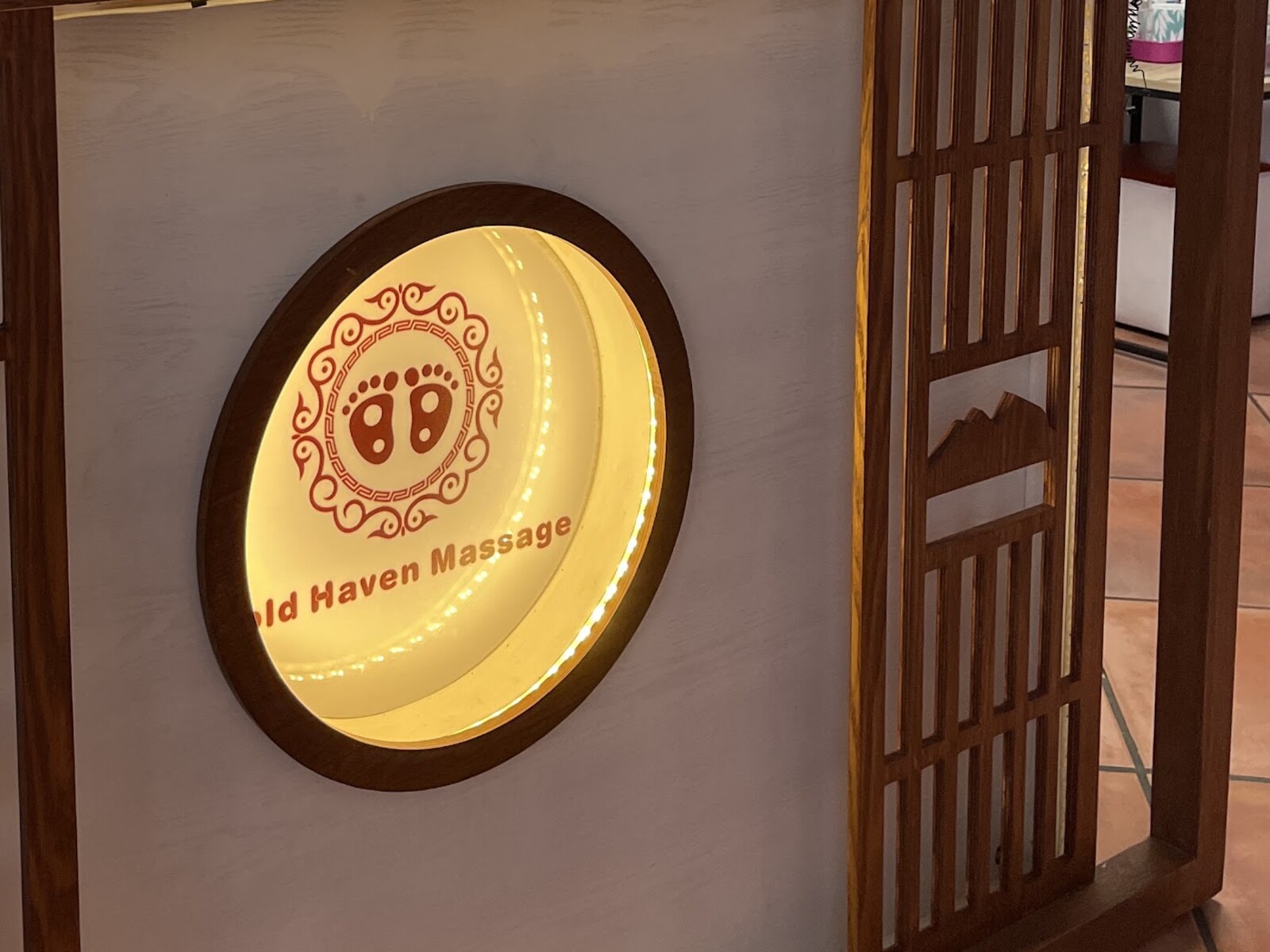 The front desk and the lit Gold Haven Massage sign